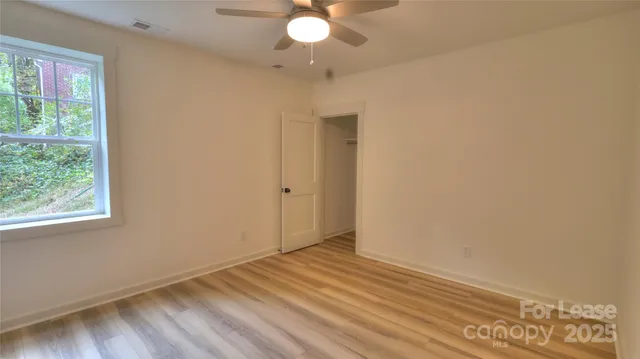 a view of empty room with wooden floor