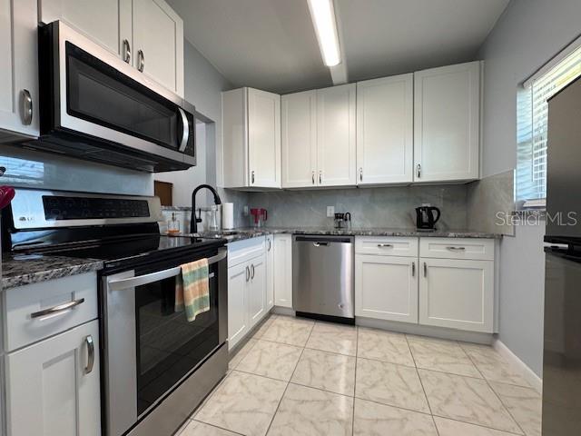 11485 Oakhurst Road, Unit 319 Largo, FL 33774 - Photo 2 of 63 a kitchen with stainless steel appliances granite countertop a stove top oven a sink dishwasher and white cabinets