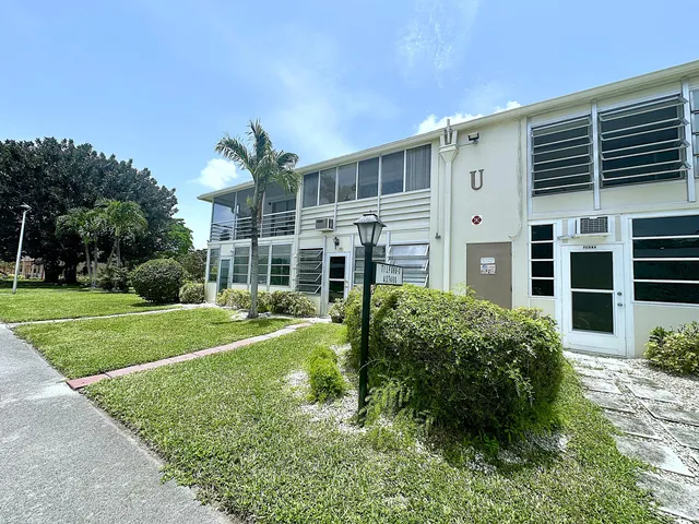 a view of a tennis ground and large trees