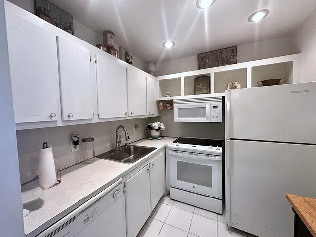 a view of a kitchen with white cabinets