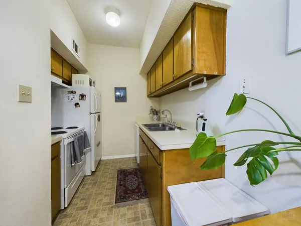 a kitchen with stainless steel appliances granite countertop a sink a stove top oven a counter space and cabinets