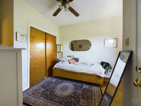 a bedroom with a bed and wooden floor