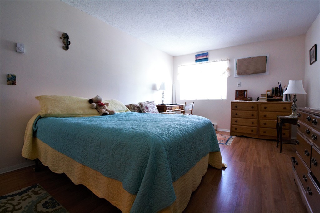 27 Round House Road, Unit 27 Bourne, MA 02532 - Photo 8 of 13 a bedroom with a bed and wooden floor