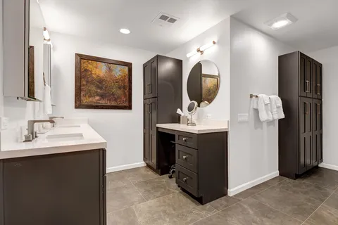 a en suite bathroom with a double vanity sink and a mirror