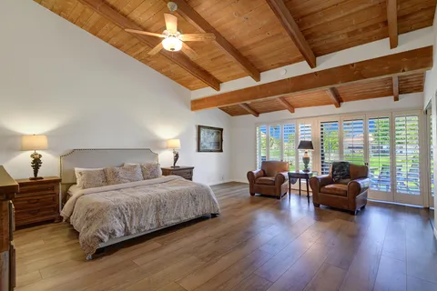 a bedroom with a large bed and wooden floor