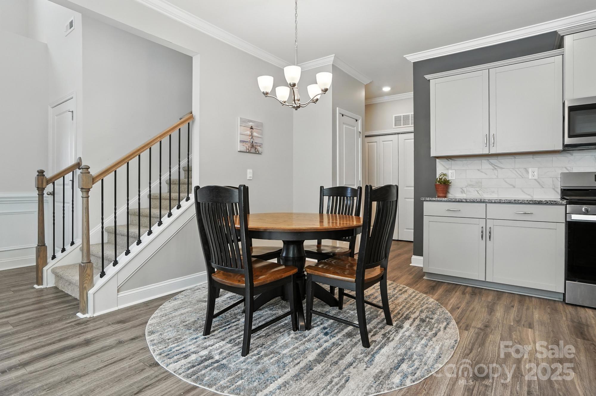7882 Iron Road Sherrills Ford, NC 28673 - Photo 12 of 46 a dining room with wooden floor a chandelier a wooden table and chairs