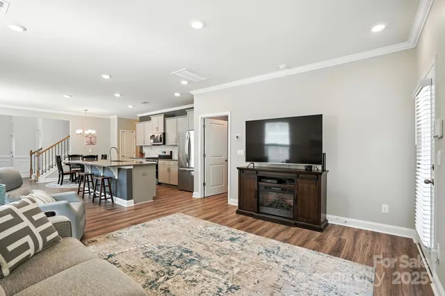 a living room with furniture a flat screen tv and a large window
