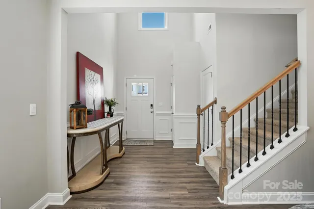 a kitchen with stainless steel appliances granite countertop a dining table chairs refrigerator and sink