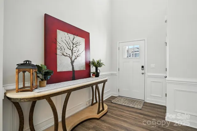 a kitchen with stainless steel appliances a refrigerator a stove a sink and white cabinets with wooden floor