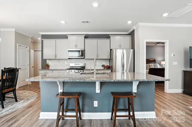 a kitchen with stainless steel appliances granite countertop a sink stove and refrigerator