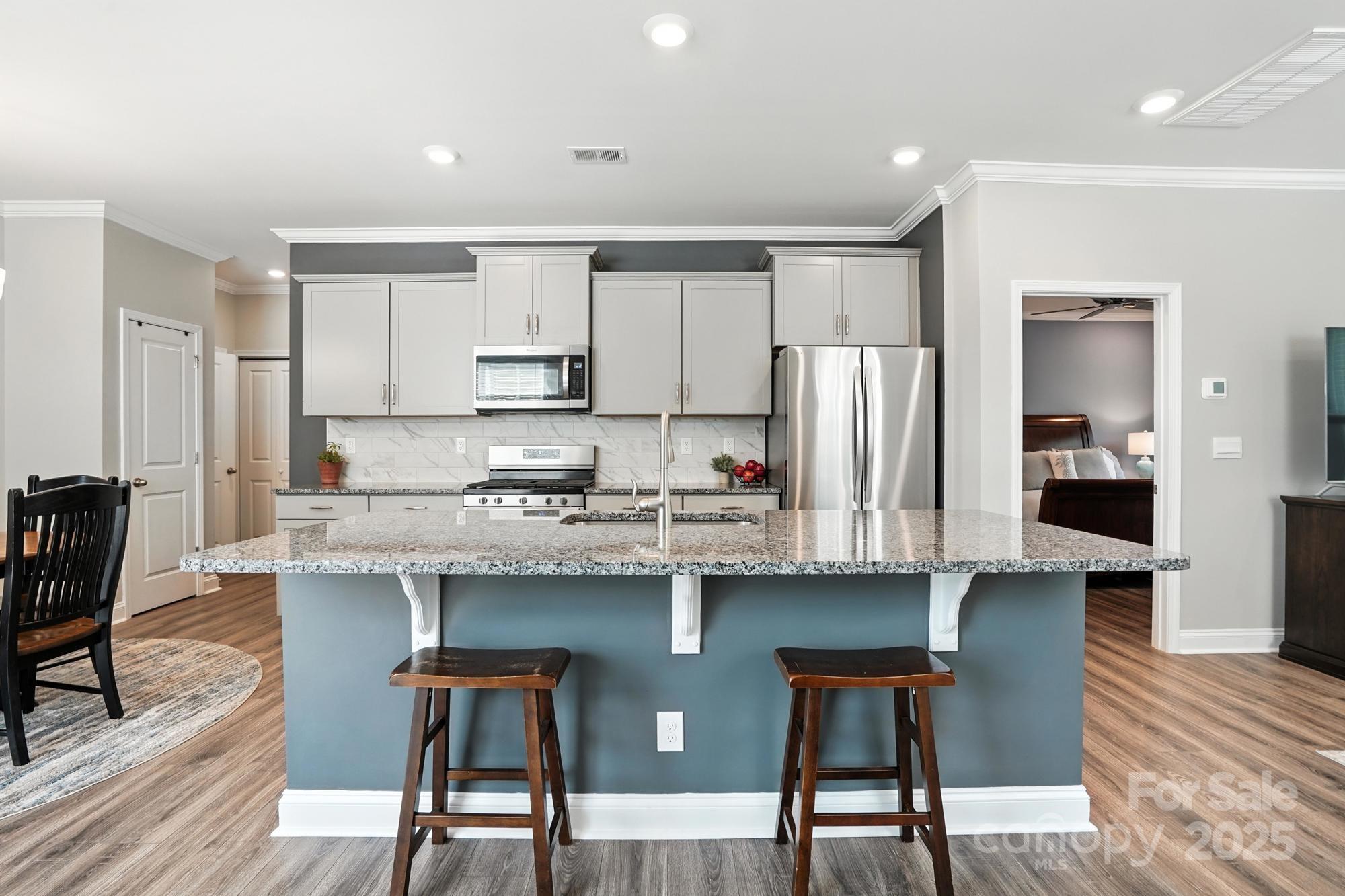 7882 Iron Road Sherrills Ford, NC 28673 - Photo 6 of 46 a kitchen with stainless steel appliances granite countertop a dining table chairs refrigerator and sink