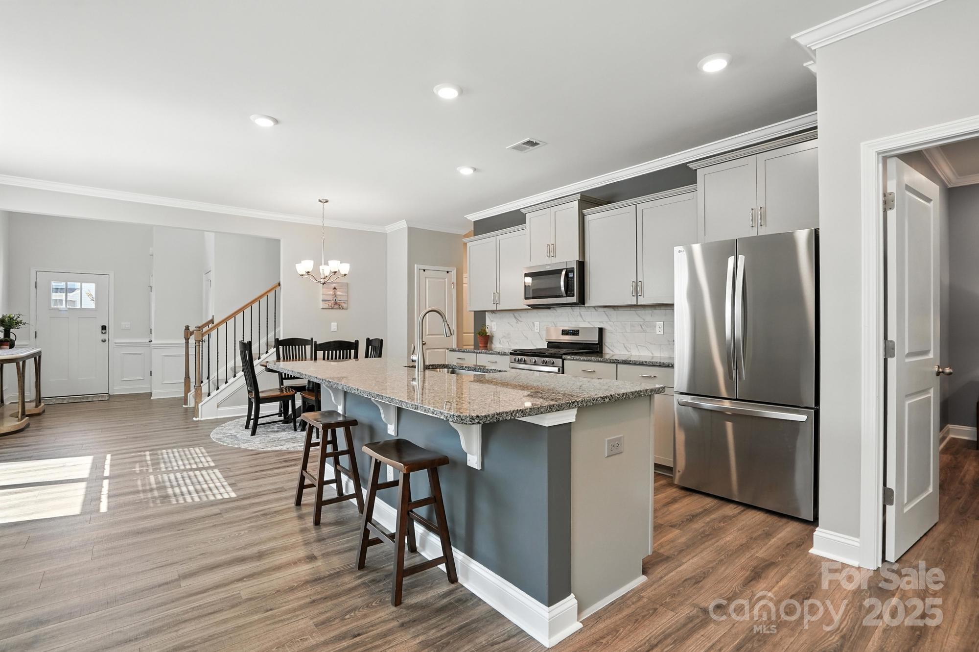7882 Iron Road Sherrills Ford, NC 28673 - Photo 9 of 46 a kitchen with stainless steel appliances a refrigerator a stove a sink and white cabinets with wooden floor