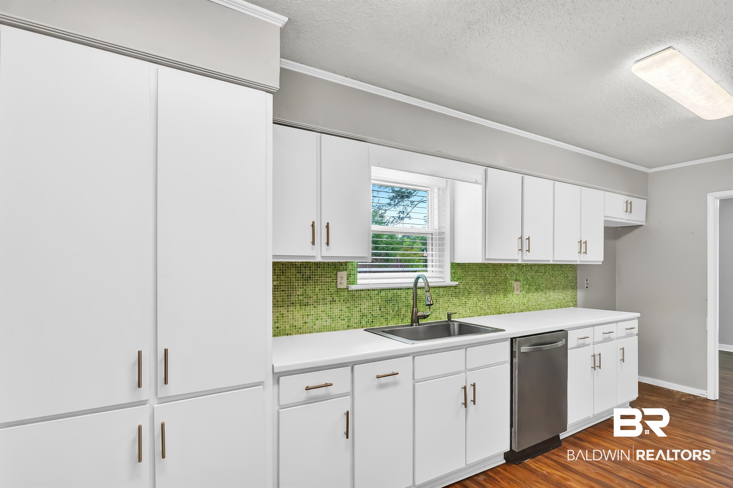 28 Caisson Trace Spanish Fort, AL 36527 - Photo 19 of 51 Kitchen featuring stainless steel dishwasher, decorative backsplash, white cabinets, a sink, and a textured ceiling