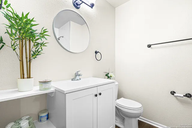 a bathroom with a sink mirror and toilet