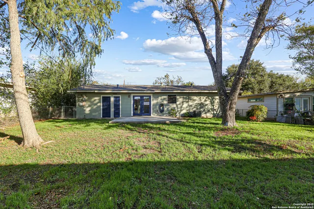 a view of a house with a yard balcony and a tree