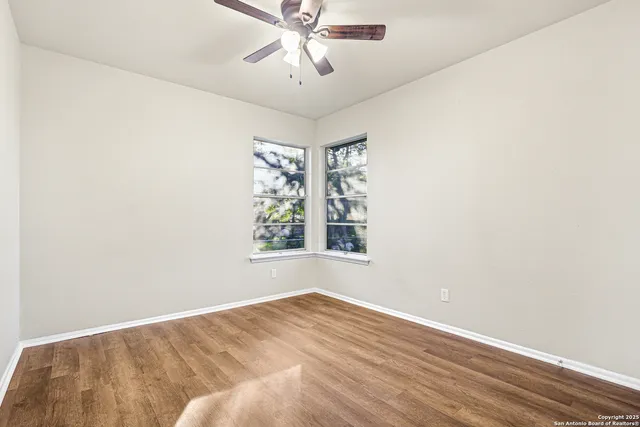 an empty room with a window and a fan
