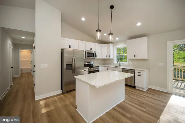 a view of a kitchen with wooden floor and a sink