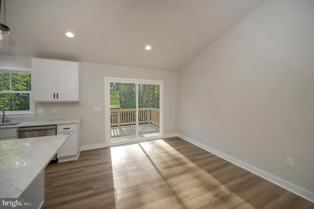 a kitchen that has a lot of white cabinets and wooden floor