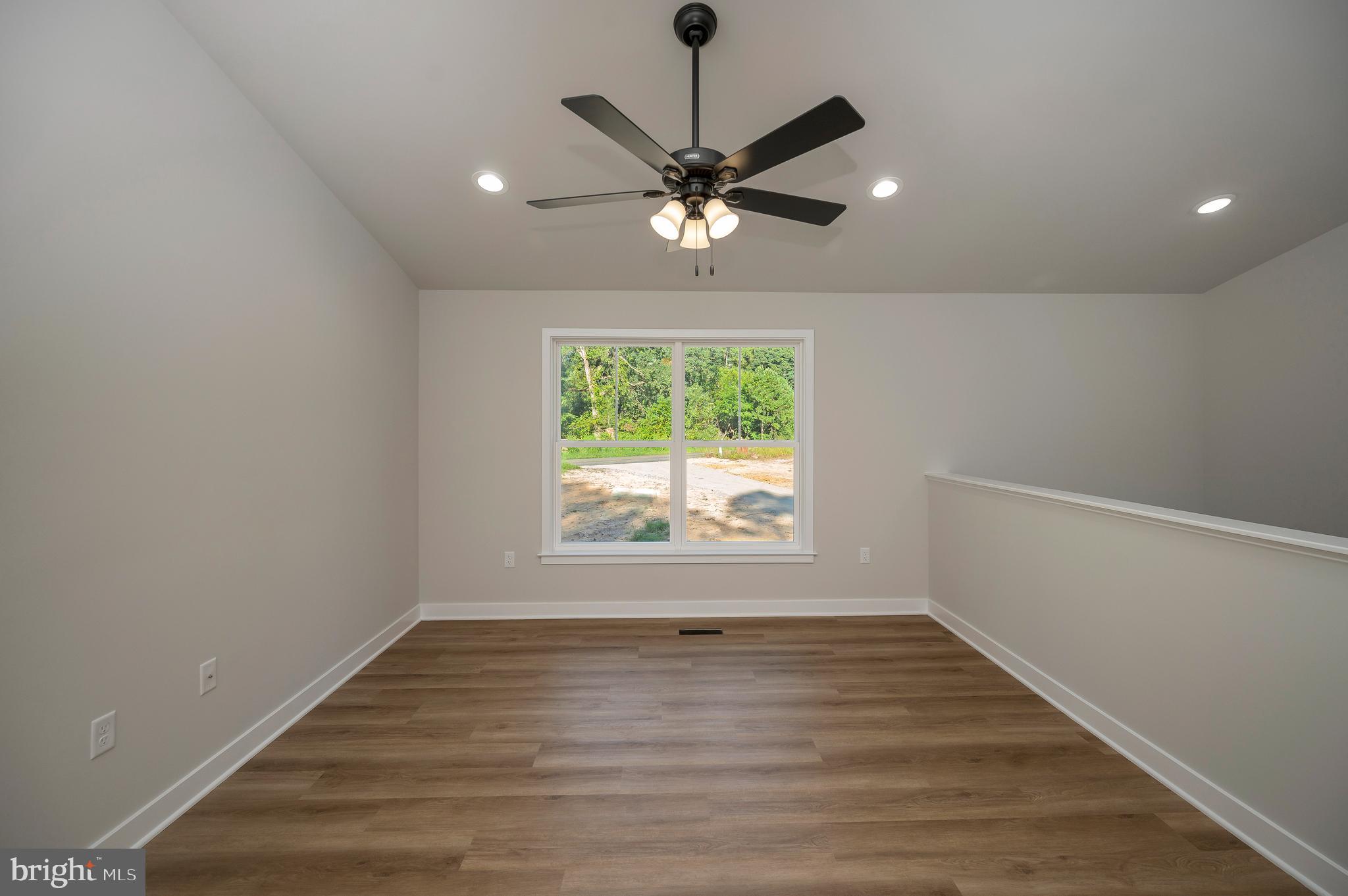 3145 Lewiston Road Bumpass, VA 23024 - Photo 17 of 44 an empty room with wooden floor fan and windows