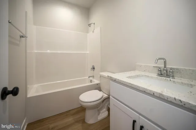 a view of a hallway with wooden floor and entryway