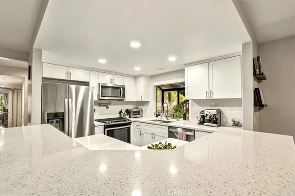 a kitchen with refrigerator a sink and a stove