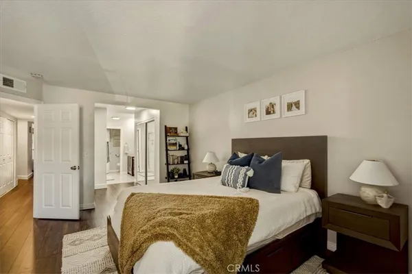 a bedroom with a bed and wooden floor