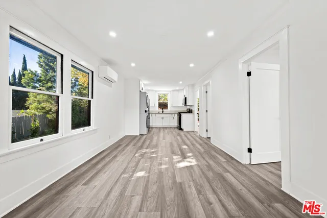 a view of empty room with wooden floor and windows