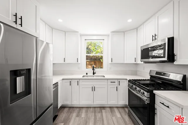 a kitchen with granite countertop a stove and a microwave area