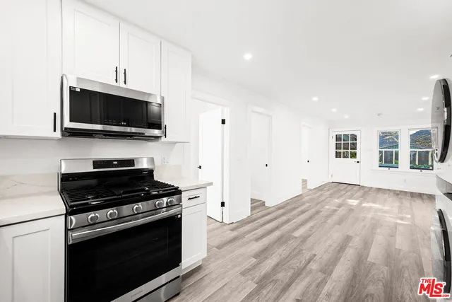 a kitchen with a stove top oven sink and cabinets