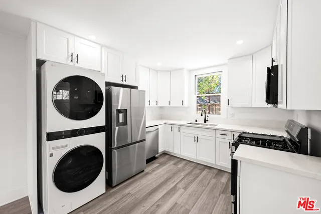 a kitchen with a refrigerator and a stove top oven