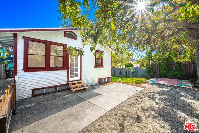 a view of a house with a tree next to a yard