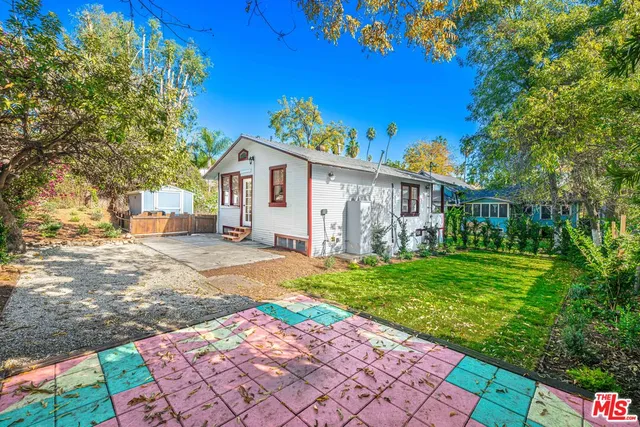a view of a house with backyard sitting area and garden