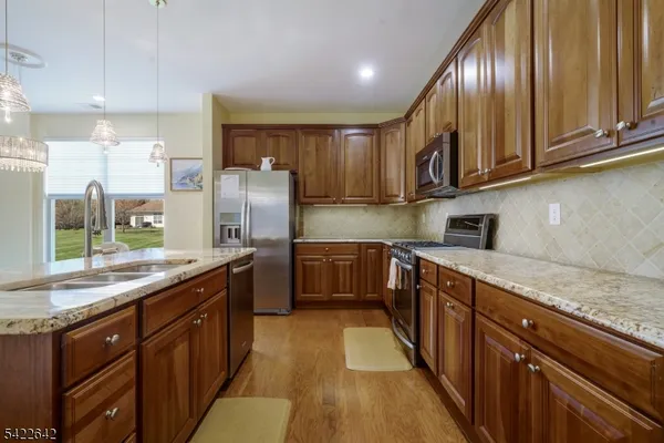 a kitchen with stainless steel appliances granite countertop wooden cabinets a sink and dishwasher