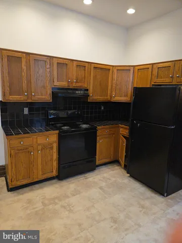 a kitchen with stainless steel appliances granite countertop a refrigerator a sink dishwasher with a stove top oven and cabinets