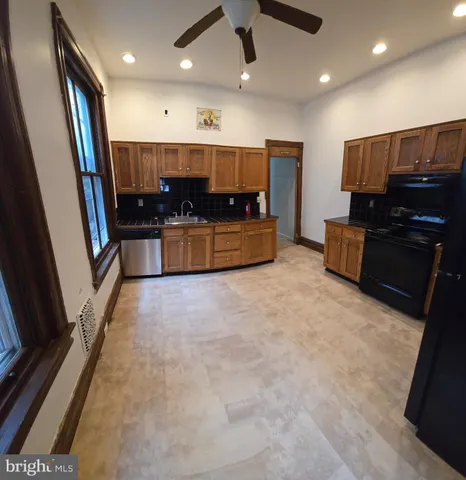 a large kitchen with a large counter top and stainless steel appliances