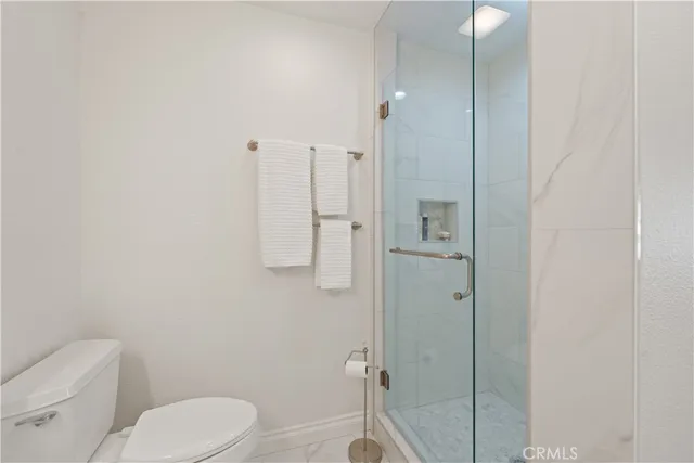 a bathroom with a toilet and a shower