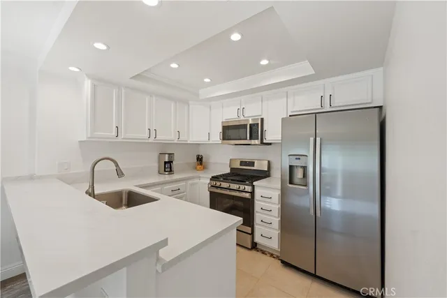 a kitchen with kitchen island stainless steel appliances cabinets a sink and a refrigerator
