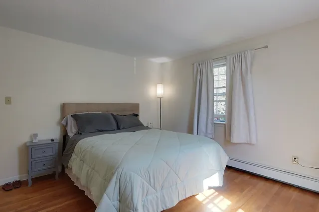 a large bed sitting in a bedroom next to a window