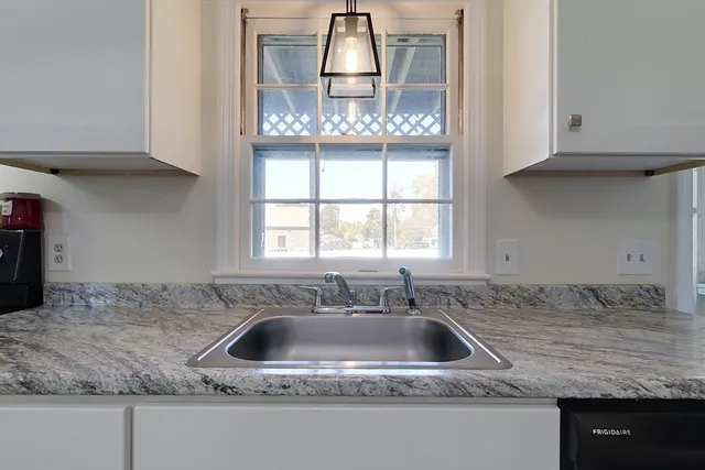 a kitchen with granite countertop a sink a window and a granite counter tops