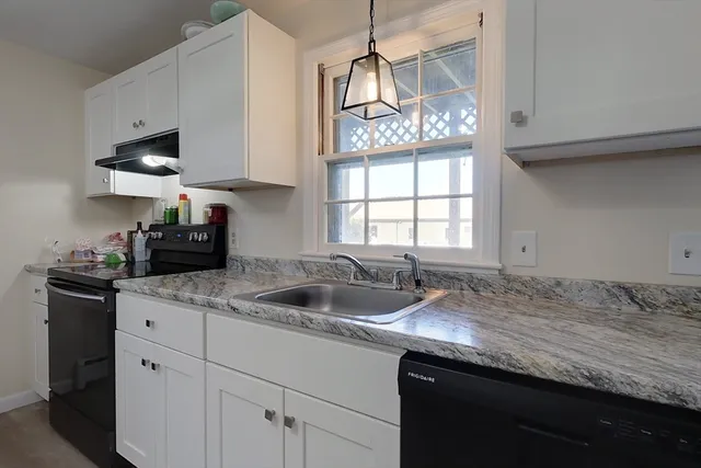 a kitchen with granite countertop a sink stainless steel appliances and cabinets