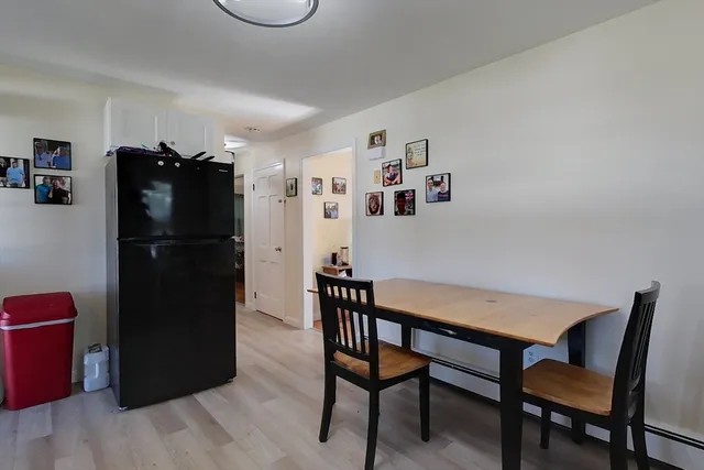 a kitchen with a refrigerator a table and chairs