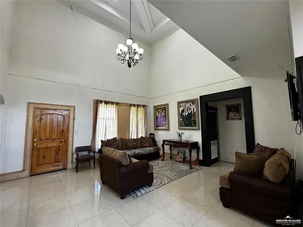 a living room with furniture a chandelier and a window