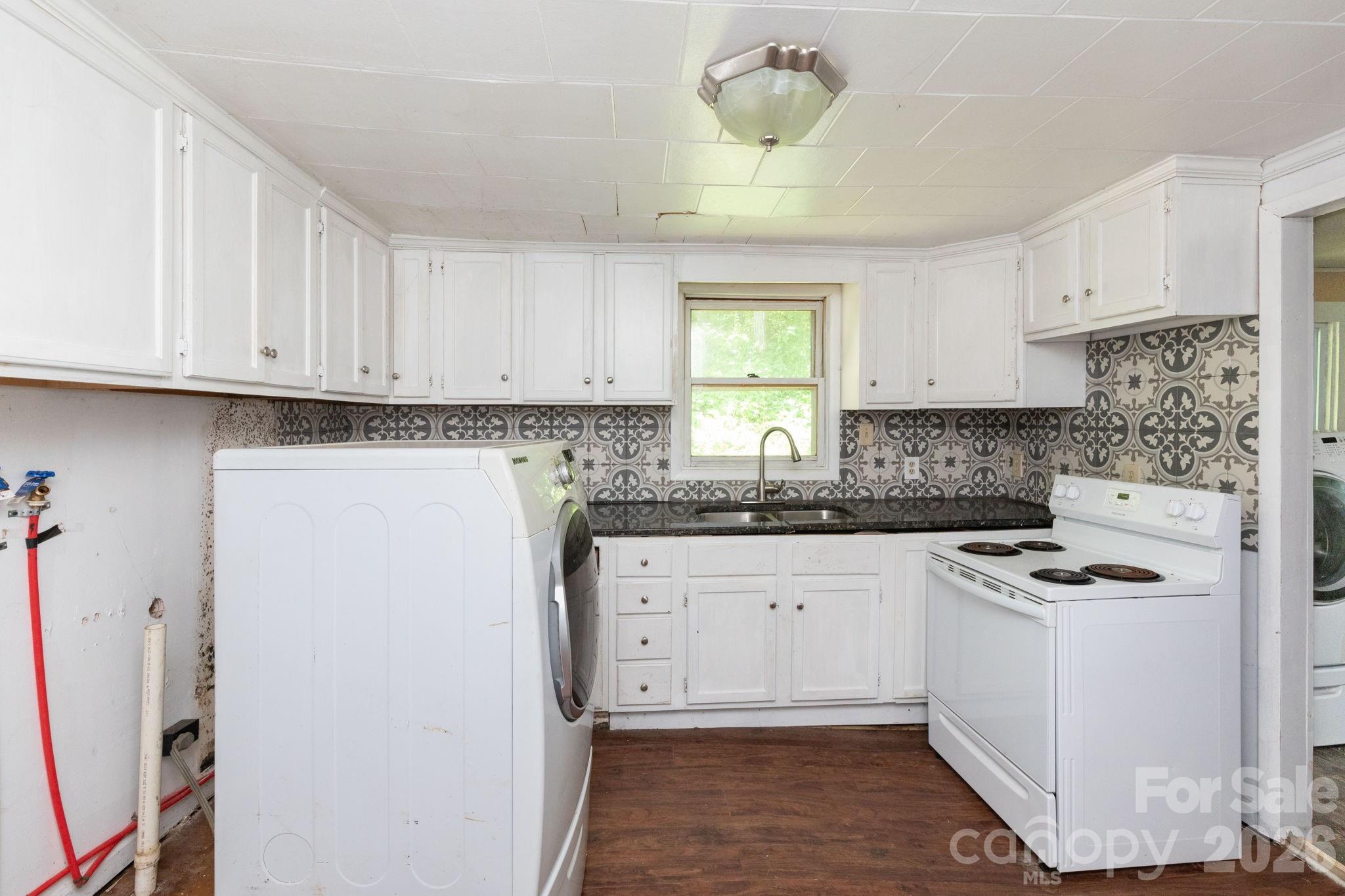 4085 Jacks Creek Road Burnsville, NC 28714 - Photo 12 of 24 a kitchen with stainless steel appliances granite countertop a stove a sink a refrigerator and white cabinets