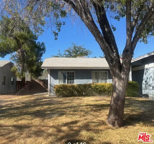 a front view of a house with a tree
