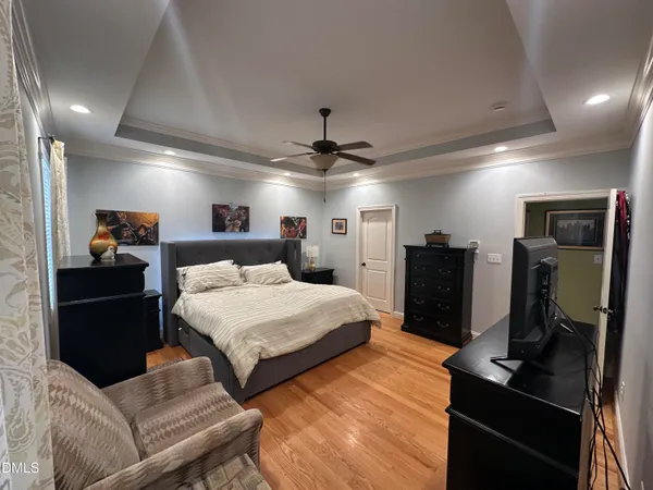 a very nice looking bedroom with a bed cabinets and a flat screen tv