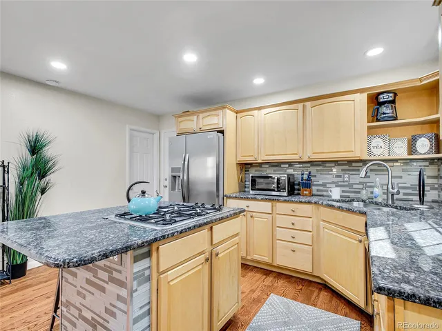a kitchen with stainless steel appliances granite countertop a stove a sink and a refrigerator