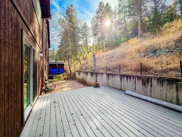 a balcony with wooden floor and trees