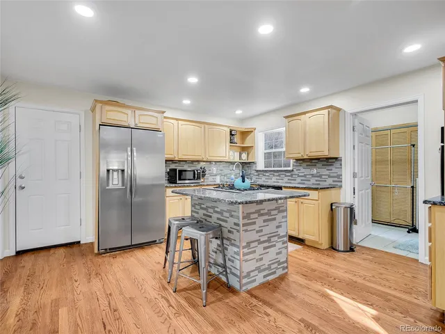 a kitchen with stainless steel appliances granite countertop a refrigerator and a stove top oven