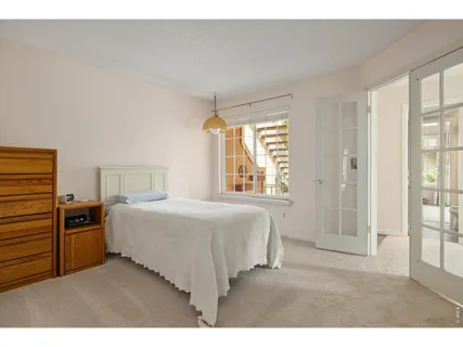 a bedroom with a bed next to a window