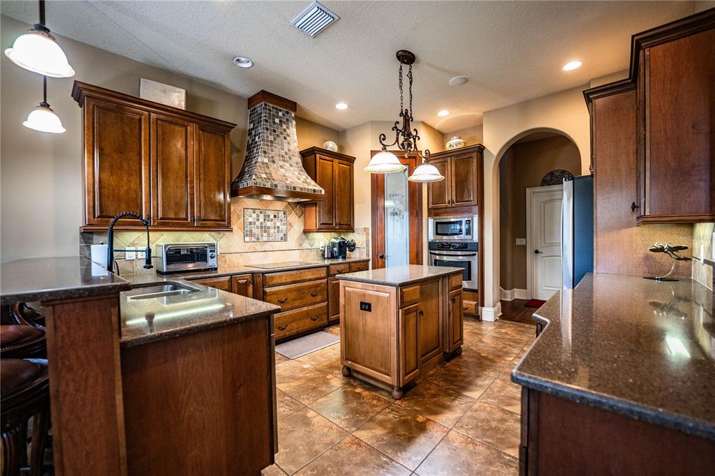 6739 Eagle Ridge Boulevard Lakeland, FL 33813 - Photo 23 of 54 a kitchen with stainless steel appliances granite countertop a sink refrigerator and cabinets